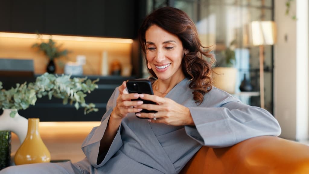 Woman smiling looking at her phone.