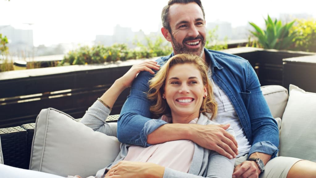 Couple relaxing on an outdoor sofa.