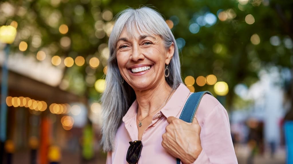 Close up face of happy retired senior woman in smart causal smiling.
