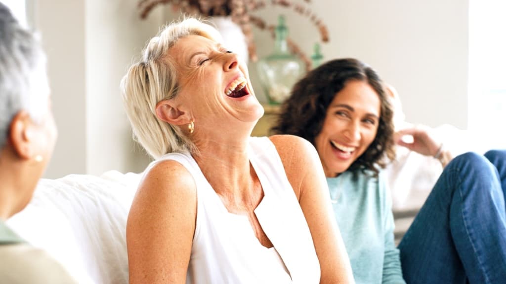 Mature woman laughing with two friends.