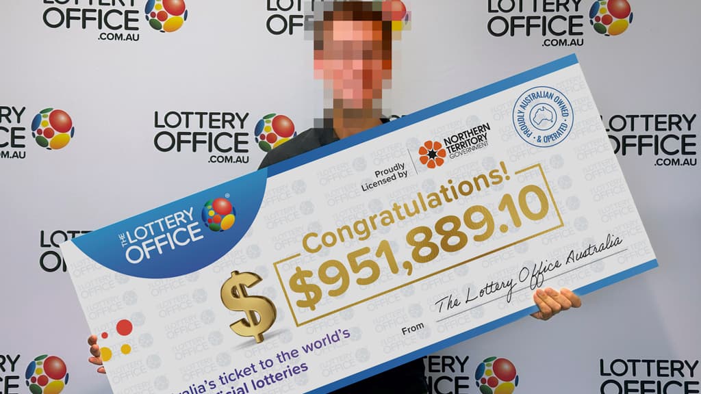 Man holding winning cheque.