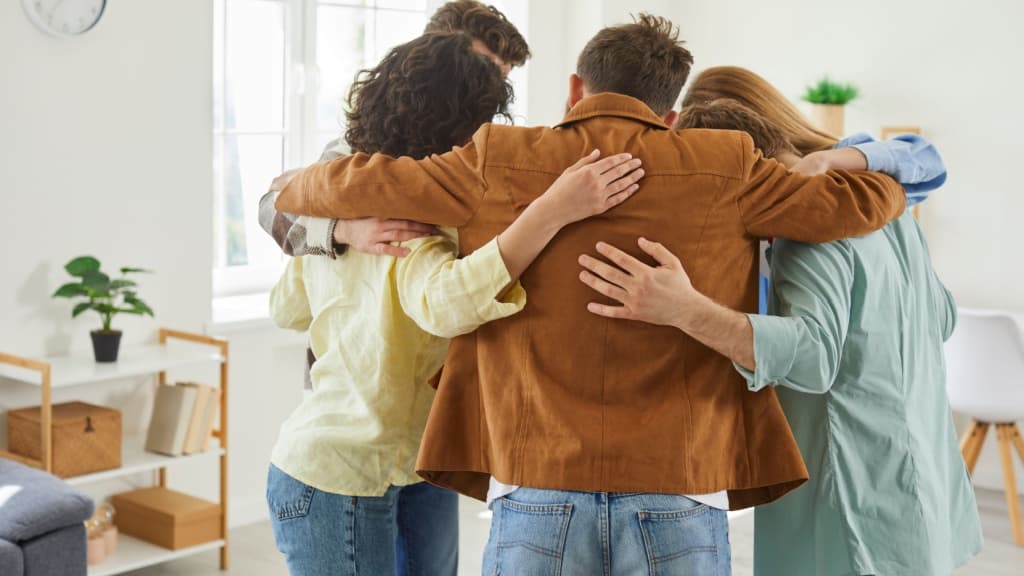Close up of a group of people hugging.