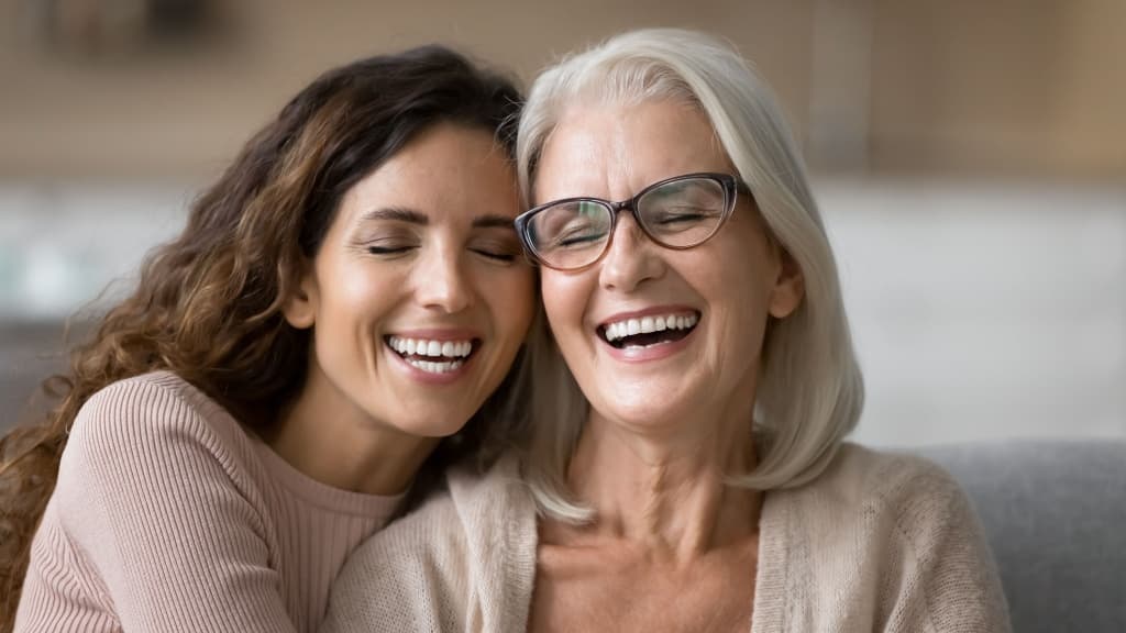 Close up of elderly mother and millennial grown-up daughter, laughing