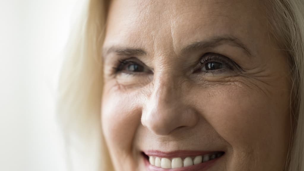 Face of happy old retired woman smiling