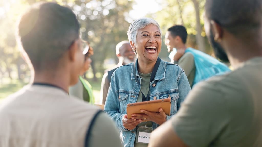 Woman volunteer holding a clipboard laughing.