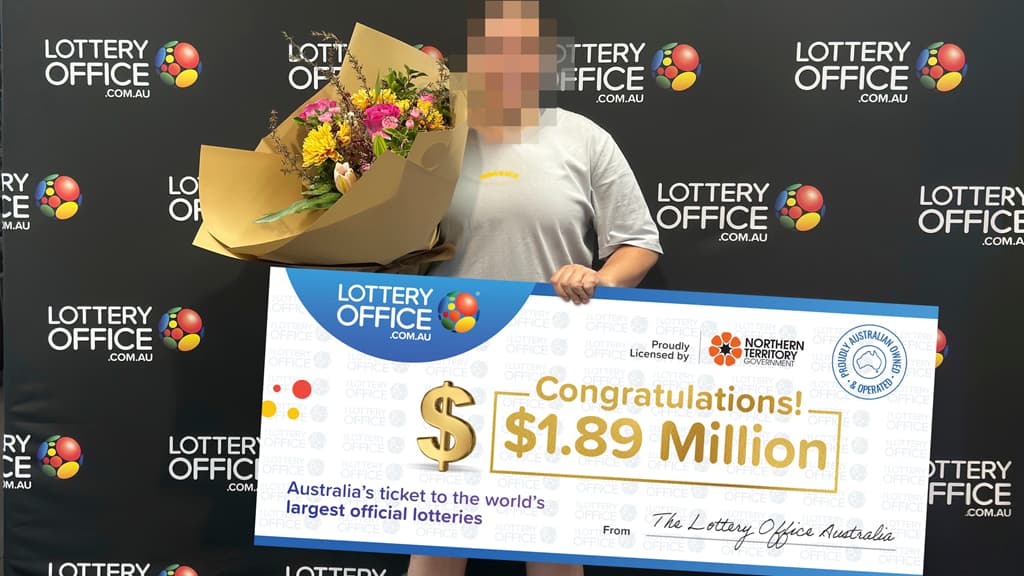 Winner holding cheque and flowers.