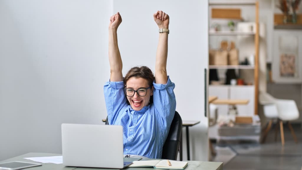 Woman celebrating at her desk