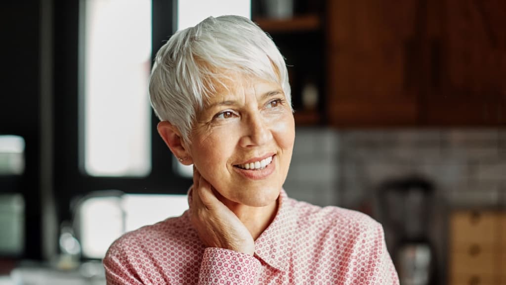Portrait of a happy senior woman by a window.