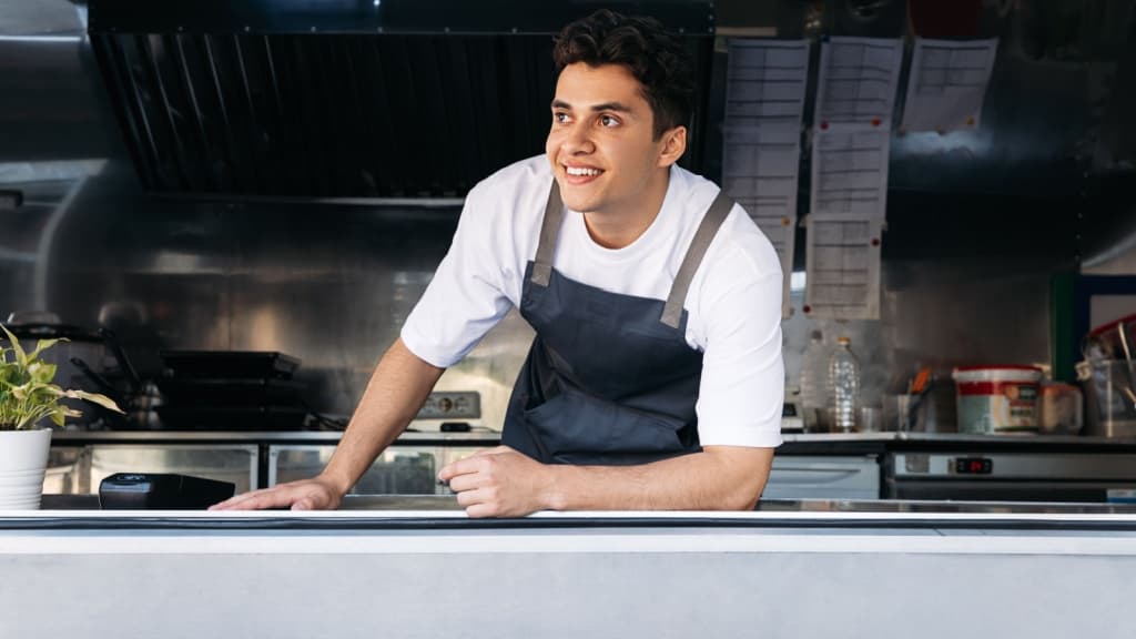 Man smiling from a food truck window.